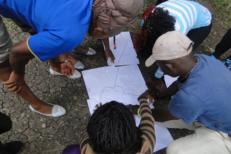 (Photo: Akiba Mashinani Trust) Researchers with the Akiba Mashinani Trust examine a map of Nairobi's Mukuru slum. In August 2017, activists succeeded in having the settlement designated as a special planning area, the first step in a process that could help transform the slum and the lives of its 300,000 residents.