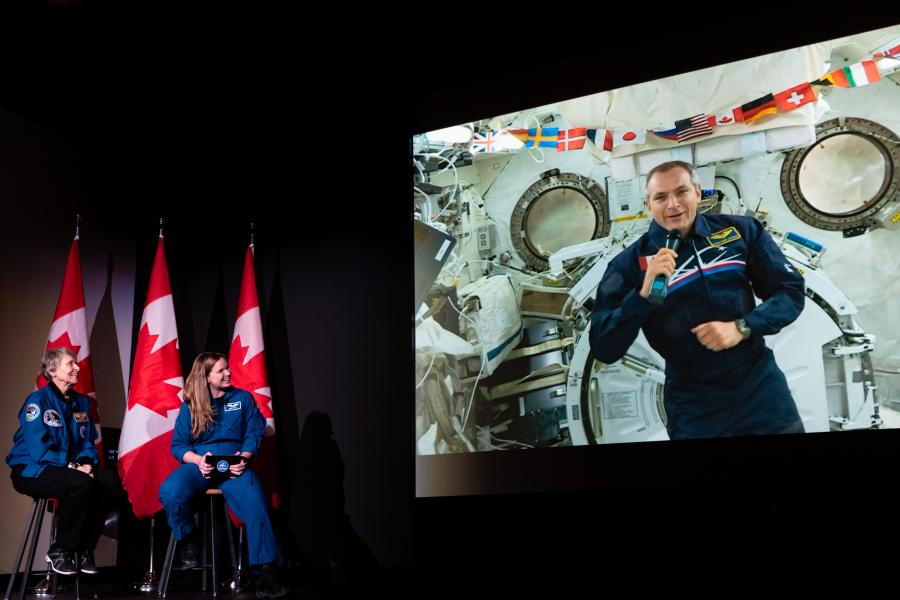 Photo: Tanya Kirnishni/Canadian Geographic Roberta Bondar, Jenni Sidey-Gibbons, and David Saint-Jacques (appearing via video link from the International Space Station) talk to students at the Canada Museum of Science and Technology