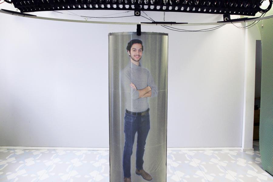 a 3D hologram of a person projected into a life-sized pod